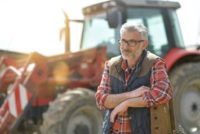 Older farmer or farm worker with a tractor