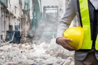 Safety professional at dusty construction site, possible silica exposure